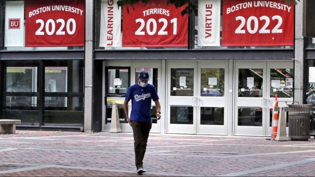 Weston Koenn, seorang mahasiswa pascasarjana dari Los Angeles, meninggalkan gedung persatuan mahasiswa Universitas Boston saat ia berjalan melalui kampus tanpa mahasiswa, Kamis, 23 Juli 2020, di Boston. (Foto: AP/Charles Krupa)