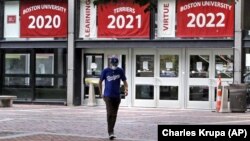 Weston Koenn, a graduate student from Los Angeles, leaves the Boston University student union building as he walks through the student-less campus, Thursday, July 23, 2020, in Boston. (AP Photo/Charles Krupa)