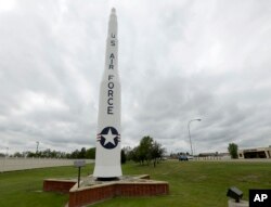 FILE - A retired Minuteman 1 missile stands at the main entrance to Minot Air Force Base, N.D., June 25, 2014. Critics of the intercontinental ballistic missiles have argued that the silos scattered across thousands of square miles of the upper Great Plains are sitting ducks in a war.