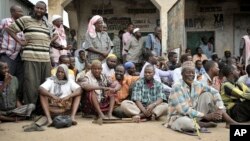 FILE - People in the Somali town of Bulomarer wait to speak with a leader after government troops help drive off al-Shabab militants Aug. 31, 2014.