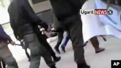 This image from amateur video made available by the Ugarit News group on Wednesday, Dec. 21, 2011, purports to show security forces entering the university in Aleppo, Syria.(AP Photo/Ugarit News Group via APTN) THE ASSOCIATED PRESS CANNOT INDEPENDENTLY VE