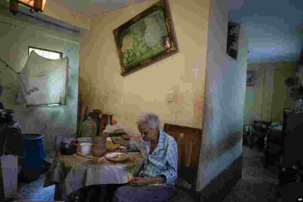 Zenobia Ansualve eats lunch at her home in Caracas, Venezuela, Aug. 18, 2021.&nbsp;The 88-year-old woman lives alone and has not left her home since the start of the COVID-19 pandemic. She said she lives on $20 a month from a room she owns and rents.