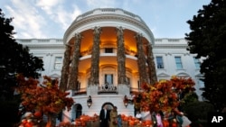 President Donald Trump and first lady Melania Trump give candy to children during a Halloween trick-or-treat event at the White House, Sunday, Oct. 28, 2018, in Washington.