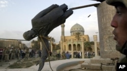 Saddam Hussein's statue is taken down in Baghdad's Firdos Square April 9, 2003 after U.S. and allied troops enter the Iraqi capital.