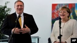 U.S. Secretary of State, Mike Pompeo, left, and German Chancellor Angela Merkel address the media during a joint statement before a meeting at the chancellery in Berlin, May 31, 2019.