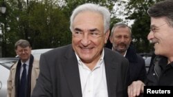 Former IMF head Dominique Strauss-Kahn (C) and Deputy Mayor of Sarcelles Francois Pupponi (2nd R), arrive at a polling station in the second round of the 2012 French presidential elections in Sarcelles, May 6, 2012.