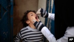 Seorang pekerja kesehatan di Yaman memberikan dosis vaksin polio kepada seorang anak laki-laki dalam kampanye imunisasi dari rumah ke rumah di Sana’a, Yaman, 21 Februari 2017.