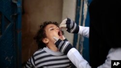 A Yemeni health worker administers a dose of polio vaccine to a boy during a house-to-house immunization campaign in Sana'a, Yemen, Feb. 21, 2017.