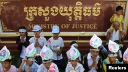 Children of women who were arrested in clashes with police during forced evictions at Boeung Kak lake, wear portraits of their mothers around their foreheads as they pray at a protest in front of the Ministry of Justice in the capital of Phnom Penh, file photo. 