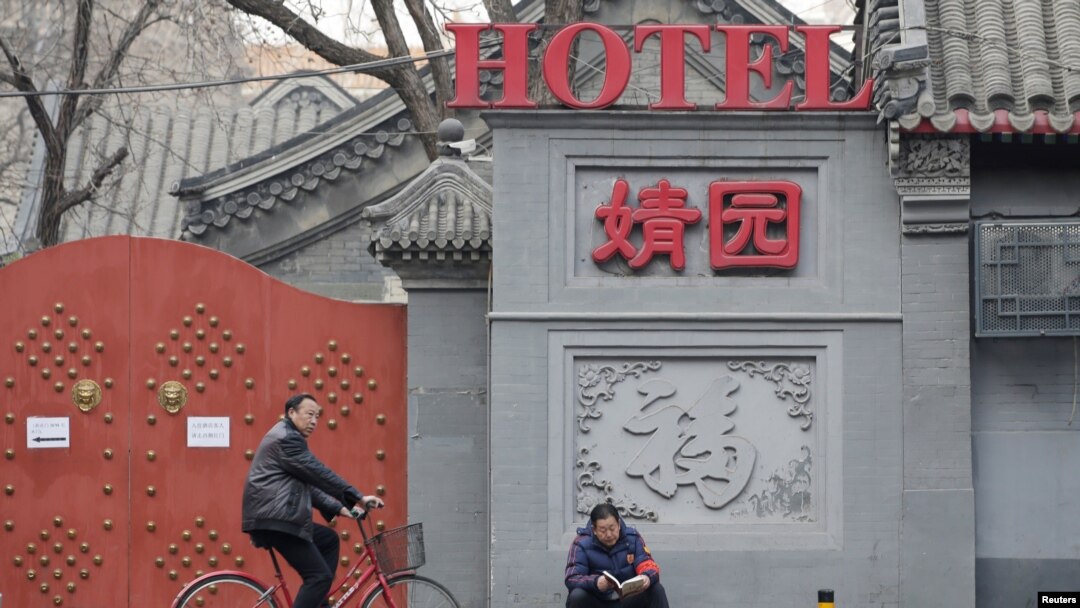 一名佩戴红袖章的北京居民自称自己是自愿保安员,在北京市中心一个胡同口执勤。(2019年2月28日)