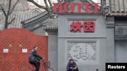 一名佩戴红袖章的北京居民自称自己是自愿保安员，在北京市中心一个胡同口执勤。（2019年2月28日）