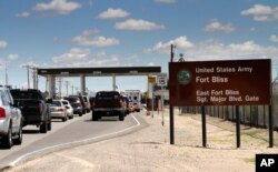FILE -- Cars wait to enter Fort Bliss in El Paso, Texas.