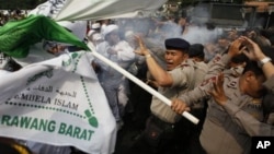 Polisi melemparkan gas air mata untuk membubarkan demonstran yang memrotes film 'Innocence of Muslims' di depan Kedutaan Besar AS di Jakarta, Senin (17/9).