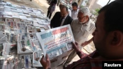 A man reads El-Watan newspaper at Tahrir square in Cairo, May 12, 2013. 