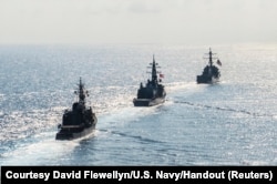 FILE - Arleigh Burke-class guided-missile destroyer USS Mustin (DDG 89) transits in formation with Japan Maritime Self-Defense Force ships JS Kirisame (DD 104) and JS Asayuki (DD 132) during bilateral training in South China Sea, April 21, 2015.
