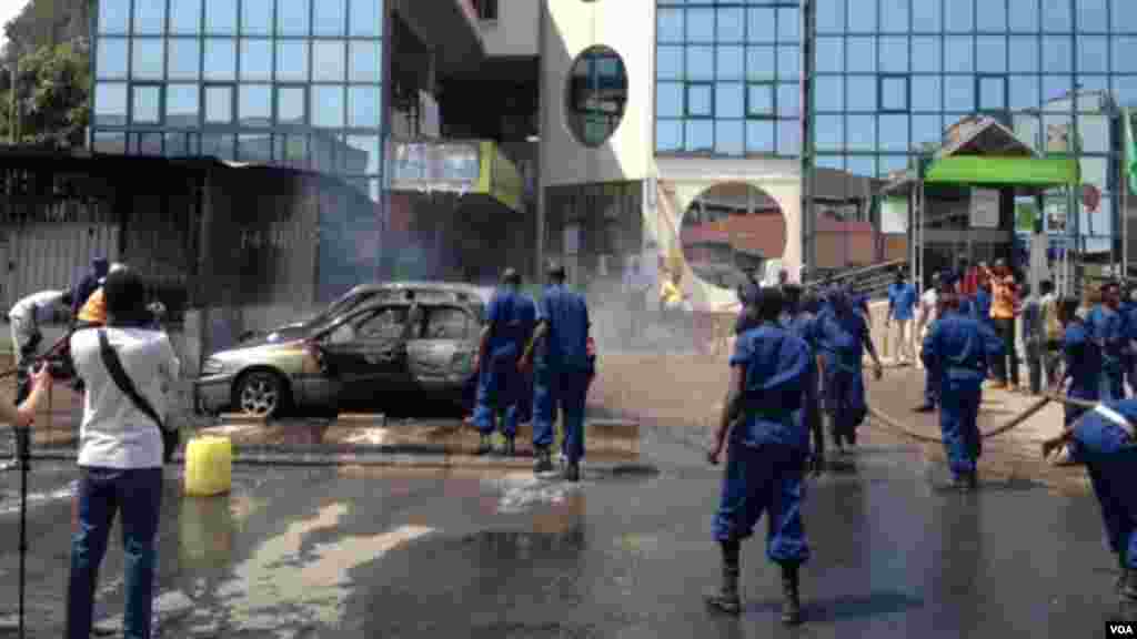 Igisasu cya gerenade cyaturikiye hanze y’inzu Kenya Commercial Bank ikoreramo I Bujumbura. Imodoka eshatu na moteri itanga amashanyarazi byahiye. (Edward Rwema / VOA)