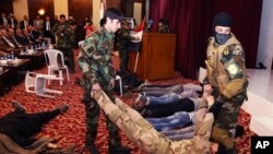 Iraqi students act out a scene in a play titled "We are all against terrorism" at Mansour Hotel in Baghdad, May 6, 2015. 