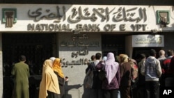 Egyptians wait at an automatic cash dispenser (ATM) in Cairo, Egypt, February 2, 2011