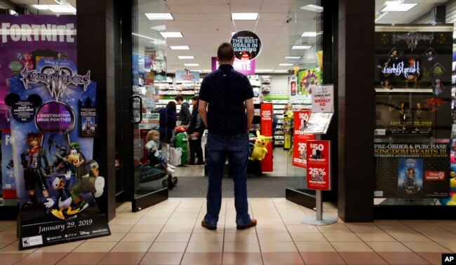 FILE - A 27-year-old self-described tech addict poses for a portrait in front of a video game store at a mall in Everett, Wash., Dec. 9, 2018.