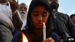 A young Pakistani Christian holds a candle to pay tribute to the Sri Lankan blasts victims during a vigil in Islamabad on April 22, 2019.
