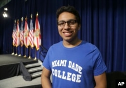 FILE - Miguel Zamudio poses for before an event where President Barack Obama spoke about the Affordable Care Act, at Miami Dade College, in Miami. Zamudio volunteers for the Democratic presidential nominee Hillary Clinton. Millennials like him are considered key in this election, not only because of their votes, but they motivate other Latinos to register and go to the polls.