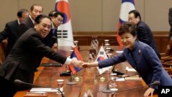 Lao President Choummaly Sayasone, left, shakes hands with his South Korean counterpart Park Geun-hye before their meeting at the presidential Blue House in Seoul, South Korea, Nov. 22, 2013.