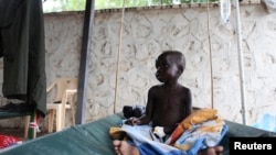 FILE - A South Sudanese child suffering from cholera sits on a bed in Juba Teaching Hospital in Juba, May 27, 2014. 