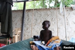 FILE - A South Sudanese child suffering from cholera sits on a bed in Juba Teaching Hospital in Juba, May 27, 2014.