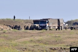 Suspected Islamic State (IS) group fighters and civilians are screened by members of the Syrian Democratic Forces (SDF) in the village of Baghuz, Syria, March 20, 2019.