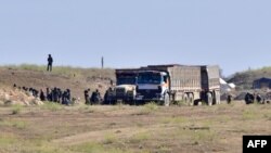 FILE - Suspected Islamic State (IS) group fighters and civilians are screened by members of the Syrian Democratic Forces (SDF) in the village of Baghuz, Syria, March 20, 2019.