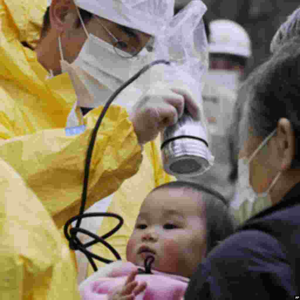 A baby is tested for radiation in Nihonmatsu, Fukushima Prefecture in northern Japan, March 15, 2011. Panic swept Tokyo on Tuesday after a rise in radioactive levels around an earthquake-hit nuclear power plant north of the city, causing some to leave the