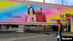 Una mujer camina frente a un cartel presidencial con la imagen del actual mandatario Daniel Ortega y la vicepresidenta Rosario Murillo en una foto tomada el 25 de septiembre de 2021. [Foto: Reuters]