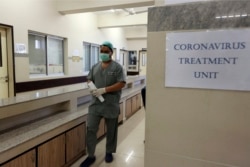 FILE - A Pakistan doctor enters an isolation ward set up as a preventative measure following the deadly Coronavirus outbreak, at the Jinnah Postgraduate Medical Center in Karachi, Feb. 3, 2020.