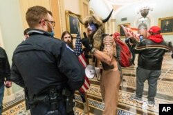 En esta foto de archivo del 6 de enero de 2021, los partidarios del presidente Donald Trump son confrontados por agentes de la Policía del Capitolio, en Washington, D.C.