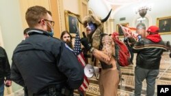 En esta foto, un simpatizante del presidente Donald Trump es confrontado por policías del Capitolio en las afueras de la sala del Senado en el Capitolio el 6 de enero. 