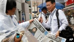 Seorang karyawan koran Jepang, Mainichi Shimbun, membagikan edisi ekstra yang melaporkan pelaksanaan hukuman mati pemimpin kultus Shoko Asahara dan enam pengikutnya di Tokyo, 6 Juli 2018. Shoko Asahara dinyatakan bersalah melakukan serangan gas sarin mematikan di stasiun-stasiun kereta bawah tanah di Tokyo pada 1995.
