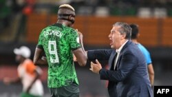 Nigeria's coach Jose Peseiro speaks with Victor Osimhen during the 2023 Africa Cup of Nations quarter-final against Angola at the Felix Houphouet-Boigny Stadium in Abidjan on February 2, 2024.