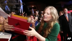 (FILE) Author and executive producer Suzanne Collins signs a book at the premiere of Lionsgate's 'The Hunger Games: Catching Fire,' in Los Angeles, California, Nov, 18, 2013.