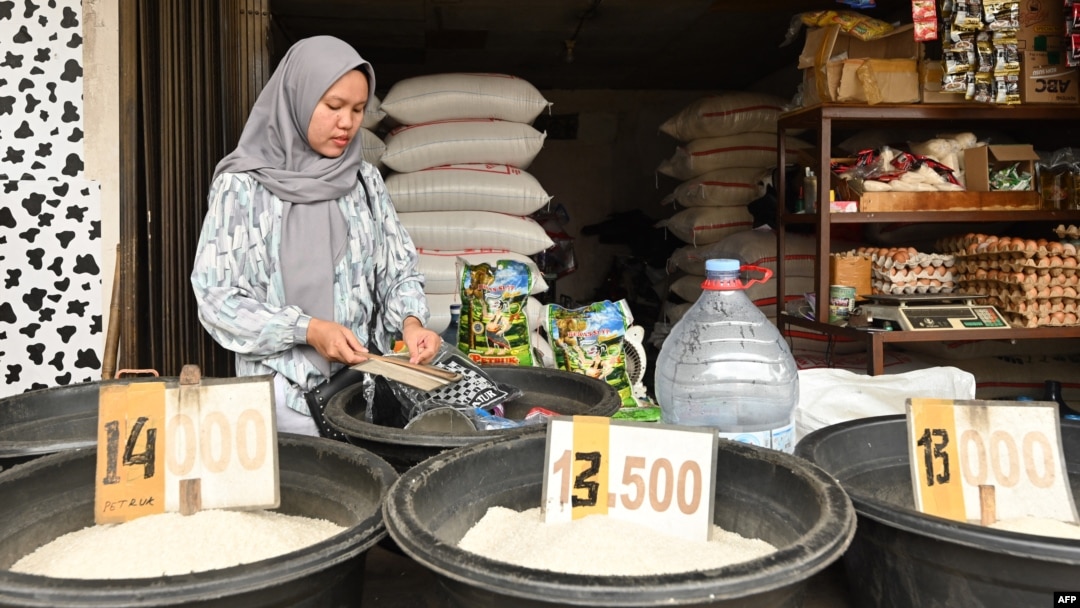 Seorang pedagang beras menunggu pelanggan di kios beras di Jakarta pada 28 Februari 2024, di tengah kenaikan harga dan kekurangan bahan pokok di Indonesia.