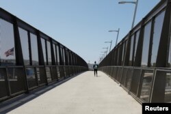 Archivo - Un solitario peatón cruza el puente de la frontera entre Estados Unidos y México en San Diego, California, el 21 de abril de 2020.