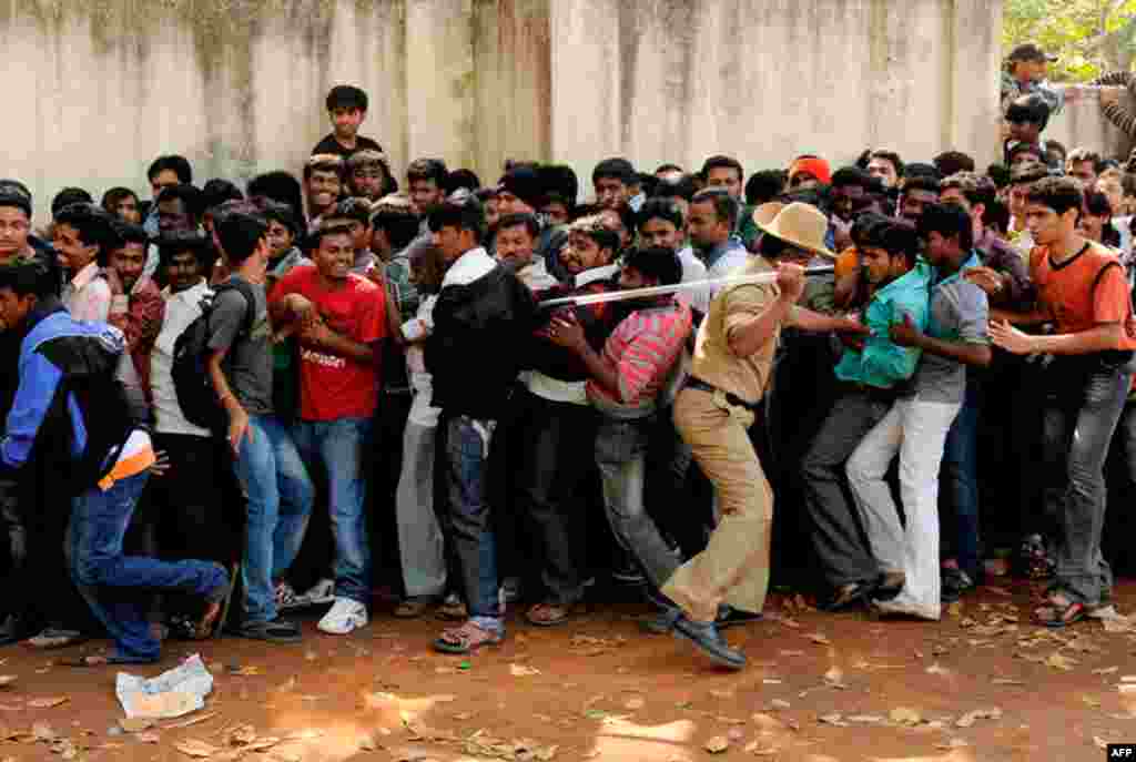 A policeman moves men back into a queue for tickets for the India and England Group B cricket World Cup match at the M. Chinnaswamy Stadium in Bangalore. (Reuters/Philip Brown)