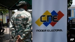 Un miembro de la milicia venezolana hace guardia cerca de un punto de registro y actualización de datos de votantes, en Caracas, este martes 16 de abril de 2024.