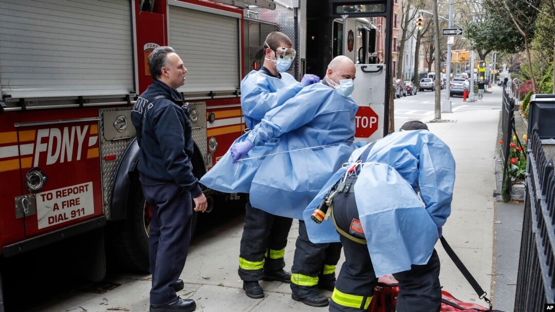 FILE - In this April 17, 2020, file photo, New York City firefighters and emergency workers suit up in protective clothing before entering Cobble Hill Health Center in the Brooklyn borough of New York.