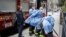 FILE - In this April 17, 2020, file photo, New York City firefighters and emergency workers suit up in protective clothing before entering Cobble Hill Health Center in the Brooklyn borough of New York. 