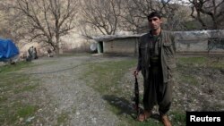 A Kurdistan Workers Party (PKK) fighter stands guard at the Qandil mountains near the Iraq-Turkish border in Sulaimaniya, 330 km northeast of Baghdad, March 24, 2013.