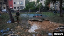 Layanan darurat Israel bekerja di lokasi serangan rudal yang, menurut militer Israel, diluncurkan dari Yaman dan mendarat di Jaffa, selatan Tel Aviv, Israel, 21 Desember 2024. (Foto: Itai Ron/Reuters)