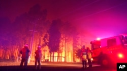 FILE - Firefighters battle a wildfire at Wooroloo, near Perth, Australia, Feb. 1, 2021. 