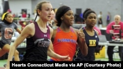 In this Friday, Feb. 14, 2020 photo, Canton High School's Chelsea Mitchell, left, beats Terry Miller, center, of Bloomfield, in the CIAC Class S track and field championships at Floyd Little Athletic Center in New Haven, Conn. (Christian Abraham/Hearst Connecticut Media via AP)