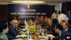 Officials of Pakistan, left, and India, right, sit on either side of a table during India-Pakistan talks in New Delhi, India, March 28, 2011. I