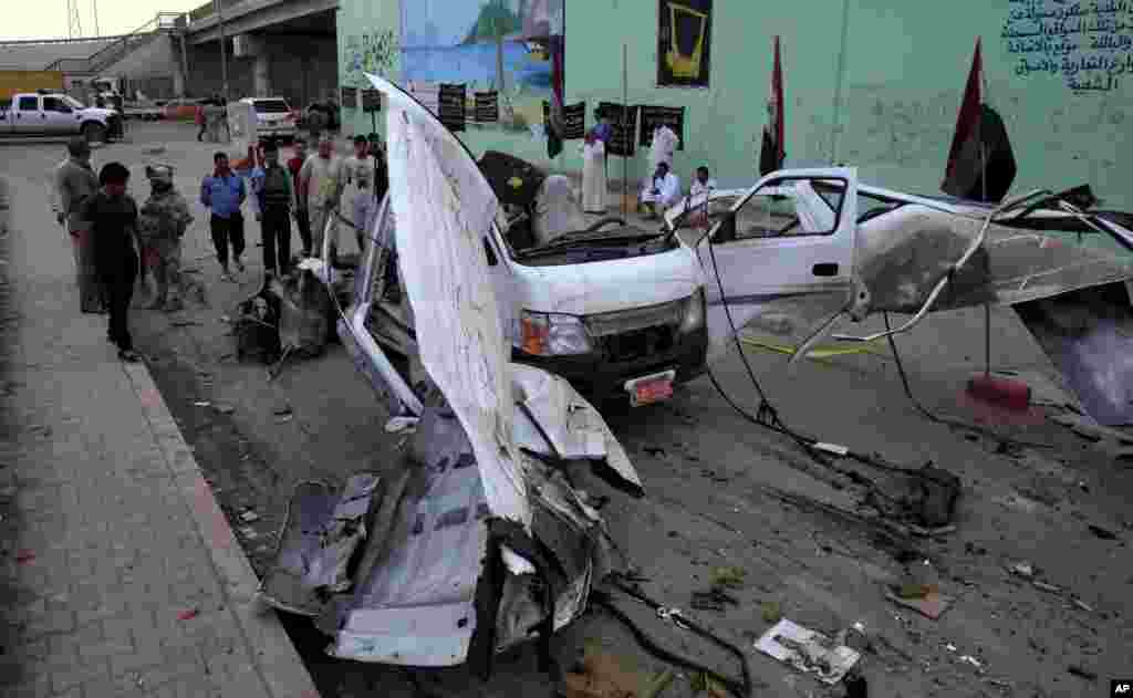 Civilians and security forces personnel gather at the scene of a car bomb attack in Husseiniyah, Baghdad, Iraq, May 6, 2013.